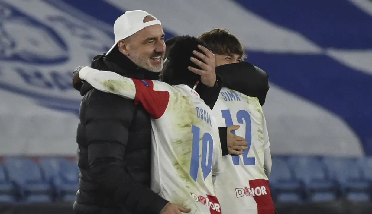 Manajer tim Slavia Praha, Jindrich Trpisovsky (kiri) merayakan kemenangan 2-0 atas Leicester City bersama para pemainnya usai berakhirnya laga leg kedua babak 32 Besar Liga Europa 2020/21 di King Power Stadium, Kamis (25/2/2021). Slavia Praha memastikan lolos ke babak 16 Besar. (AP/Rui Vieira)