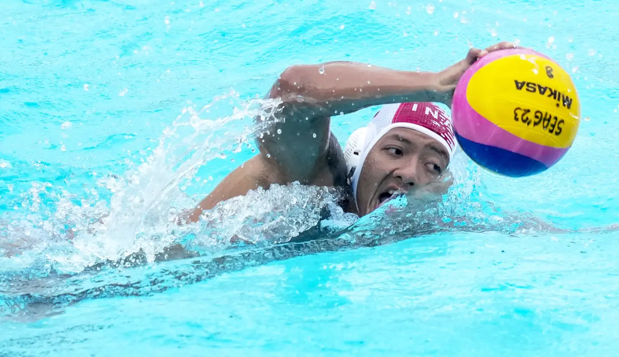 Pemain Tim Polo Air Indonesia, Ahmad Fauzi membawa bola saat melawan Tim Polo Air Kamboja pada nomor polo air putra SEA Games 2023 di Phnom Penh, Kamboja, Jumat (13/05/2023). Indonesia menang telak dengan skor 37-2. (AP Photo/Tatan Syuflana)