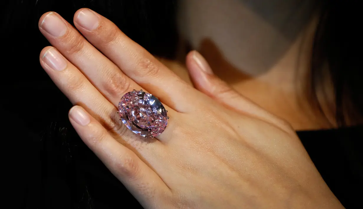 Model mengenakan cincin berlian "The Pink Star" sebelum dilelang oleh Sotheby di London, 20 Maret 2017. Berlian merah muda ini adalah berlian terbesar yang pernah dikurasi Geological Institute of America (GIA). (AP Photo/Kirsty Wigglesworth)