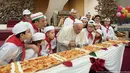 Paus Fransiskus meniup lilin kue ulang tahunnya yang tertancap di atas pizza panjang bersama dengan anak-anak di Vatikan, Minggu (17/12). Setelah meniup lilin, mereka menikmati pizza yang dibuat hingga panjang 4 meter. (L'Osservatore Romano/Pool via AP)