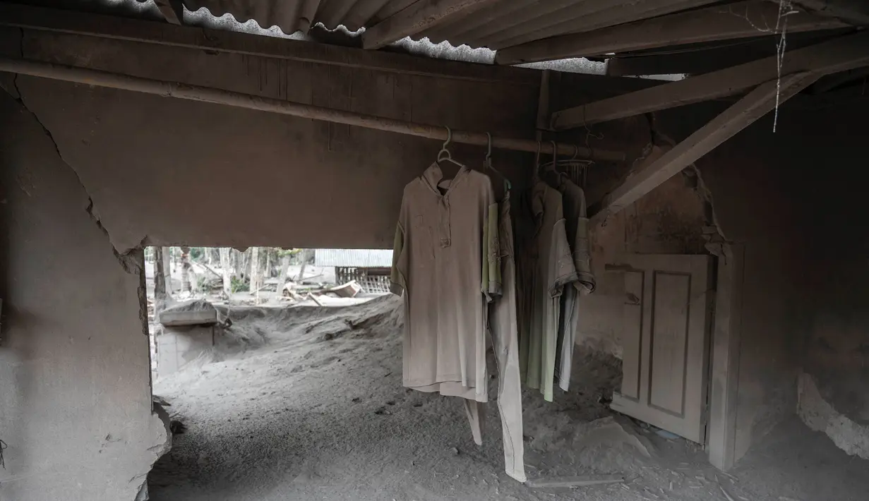 Sebuah rumah yang rusak tertutup abu vulkanik dari Gunung Semeru di Desa Sumber Wuluh, Lumajang, Jawa Timur, Senin (6/12/2021). Desa Sumber Wuluh luluh lantak diterjang erupsi Semeru mengakibatkan puluhan rumah rusak dan ratusan warga mengungsi. (Juni Kriswanto/AFP)