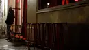 Seorang pria berdiri dekat kursi kosong di luar bar yang tutup di Paris pada Senin (5/10/2020). Bar dan kafe di Paris serta pinggiran kota terdekatnya ditutup mulai 6 Oktober selama dua minggu karena ibu kota Prancis ditempatkan pada kewaspadaan maksimum  Covid-19. (GEOFFROY VAN DER HASSELT/ AFP)
