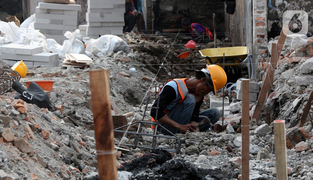 Seorang pekerja berakivitas di antara reruntuhan bangunan pasca kebakaran Pasar Gembrong di Cipinang Besar Utara, Jakarta, Senin (4/7/2022). Revitalisasi permukiman korban kebakaran Pasar Gembrong di RW 001 ini ditargetkan rampung pada September 2022 mendatang serta menelan biaya Rp7,8 miliar. (Liputan6.com/Faizal Fanani)