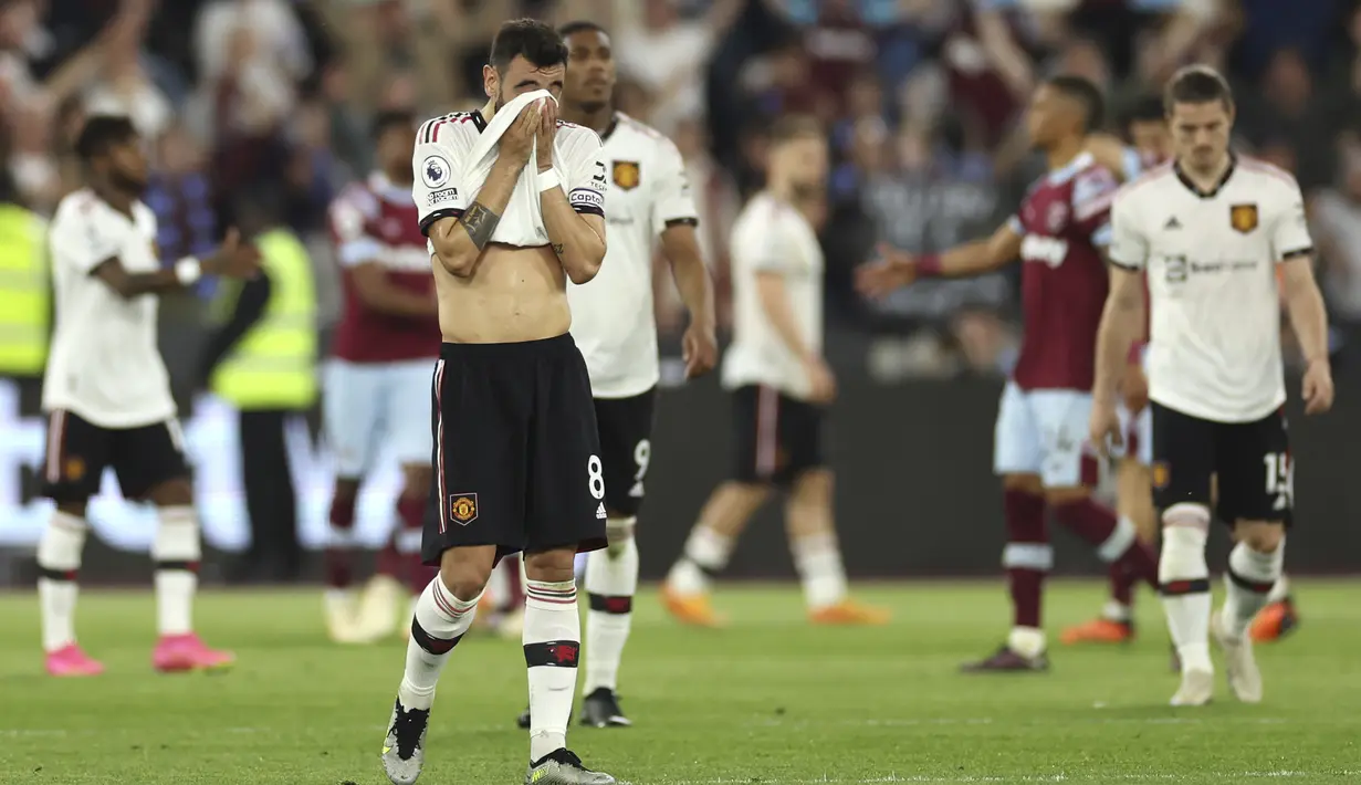 <p>Gelandang Manchester United, Bruno Fernandes (tengah) menutupi wajahnya setelah pertandingan melawan West Ham United pada pertandingan lanjutan Liga Inggris di Stadion London di London, Inggris, Senin, 8 Mei 2023. (AP Photo/Ian Walton)</p>