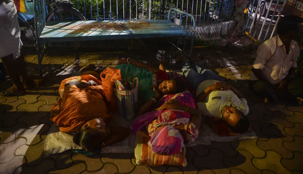 Warga berkemah semalam untuk mendapatkan suntikan vaksin Covid-19 keesokan harinya di RSUD Siliguri, negara bagian Bengal Barat, India, Senin (20/9/2021). Sebanyak 202 juta orang India telah divaksin dua dosis atau lengkap hingga 19 September 2021. (Diptendu DUTTA/AFP)