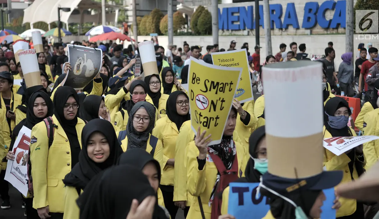 Mahasiswa Universitas Indonesia (UI) membawa spanduk saat menggelar kampanye Bahaya Merokok di car free day (CFD), Jakarta, Minggu (6/5). Dalam aksi tersebut para mahasiswa juga menyerukan tentang bahaya merokok. (Merdeka.com/Iqbal Nugroho)