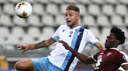 Gelandang Lazio, Sergej Milinkovic, berebut bola dengan pemain Torino pada laga lanjutan Serie A pekan ke-29 di Stadion Olimpico Grande Torino, Rabu (1/7/2020) dini hari WIB. Lazio menang 2-1 atas Torino. (AFP/Isabella Bonotto)