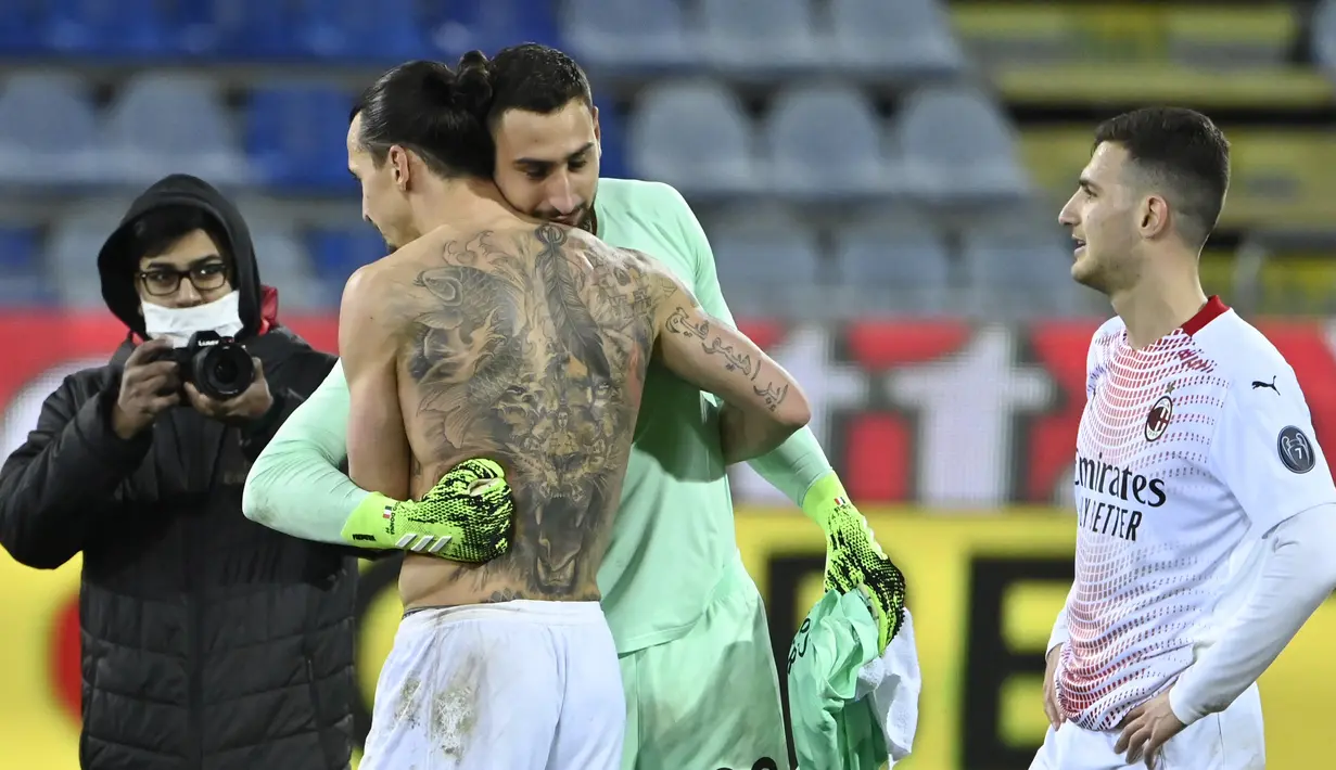 Penyerang AC Milan, Zlatan Ibrahimovic memeluk kiper Gianluigi Donnarumma usai pertandingan melawan Cagliari pada lanjutan Liga Serie A Italia di Sardegna Arena, Selasa (19/1/2021). (AFP/Alberto Pizzoli)