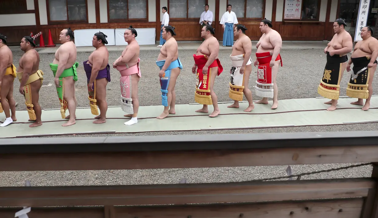 Sejumlah pegulat sumo berbaris untuk berdoa di Kuil Yasukuni di Tokyo, Jepang, Senin (17/4). (AP Photo / Shizuo Kambayashi)