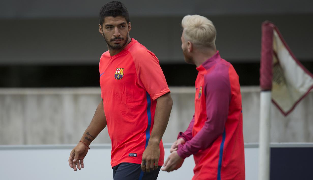 Luis Suarez dan Messi berbincang pada sesi latihan jelang laga melawan Celtic pada ajang International Champions Cup 2016 di St George's Park, Inggris (25/7/2016). (AFP/Oli Scarff)