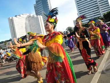 Kelompok seniman T-Ta asal Universitas Paramadina menari saat car free day di Bundara HI, Jakarta, Minggu (26/4/2015). Mereka meminta sumbangan kepada warga untuk mengikuti Interntional Folklore Festival di Spanyol. (Liputan6.com/Faizal Fanani)