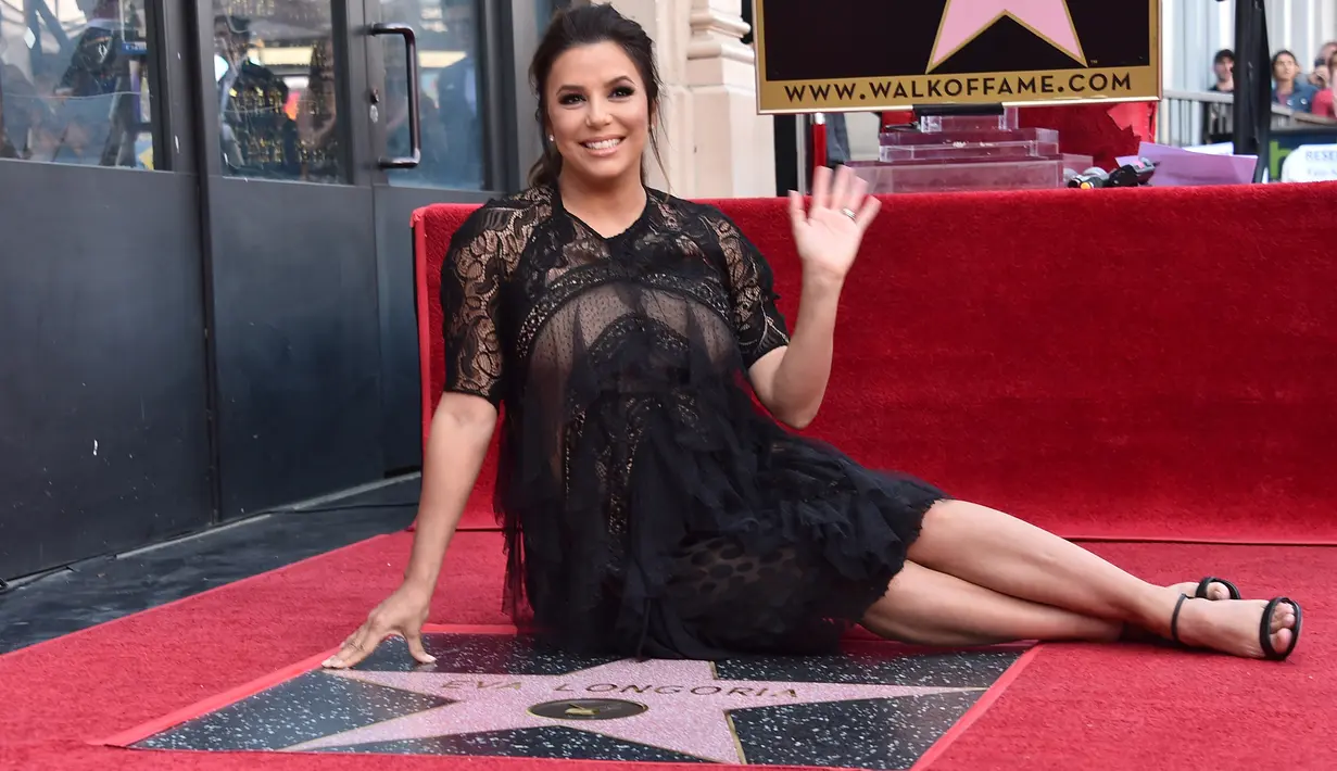Aktris Eva Longoria berpose dengan bintang Hollywood Walk of Fame miliknya saat acara penghargaan di Los Angeles, Senin (16/4). Eva Longoria merupakan penerima bintang ke-2.634 di kategori Televisi. (Alberto E. Rodriguez/GETTY IMAGES/AFP)