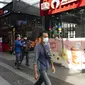 Para pejalan kaki memakai masker saat berjalan di distrik perbelanjaan di Kuala Lumpur, Malaysia, Kamis (14/1/2021). Otoritas Malaysia memperketat pembatasan pergerakan untuk mencoba menghentikan penyebaran virus corona COVID-19. (AP Photo/Vincent Thian)