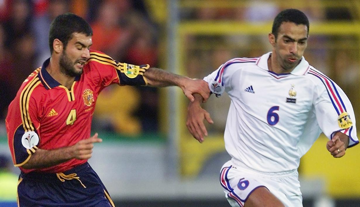 Pep Guardiola berebut bola dengan Youri Djorkaeff pada laga perempat final Euro 2000 antara Spanyol dan Prancis di Bruges 25 Juni 2000. (AFP/Olivier Morin)