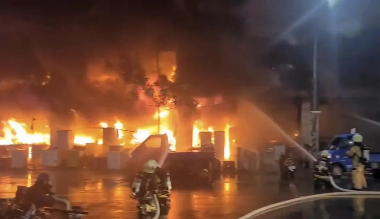 Petugas pemadam kebakaran memadamkan api di sebuah gedung di Kaohsiung, Taiwan selatan, Kamis (14/10/2021). Petugas pemadam kebakaran membutuhkan waktu lebih dari empat jam untuk memadamkan api. (EBC via AP )