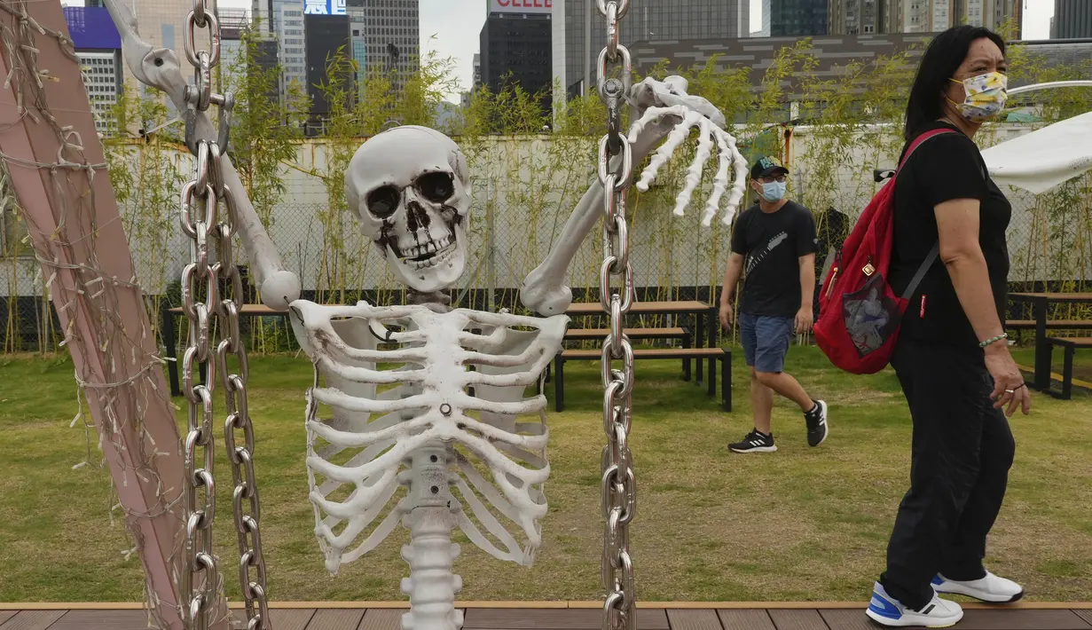 Sebuah replika kerangka  manusia ditampilkan sebagai bagian dari dekorasi Halloween di sebuah taman di Hong Kong, Rabu  (27/10/2021). Tahun ini, perayaan tersebut jatuh pada hari Minggu, 31 Oktober 2021. (AP Photo/Vincent Yu)