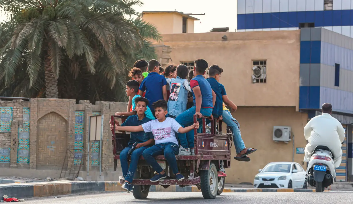 Anak-anak bermain di sebuah taman selama liburan Idul Fitri di Basra, Irak, Senin, (25/5/2020). Idul Fitri menandai berakhirnya bulan suci puasa Ramadan. (AP Photo/Nabil al-Jurani)