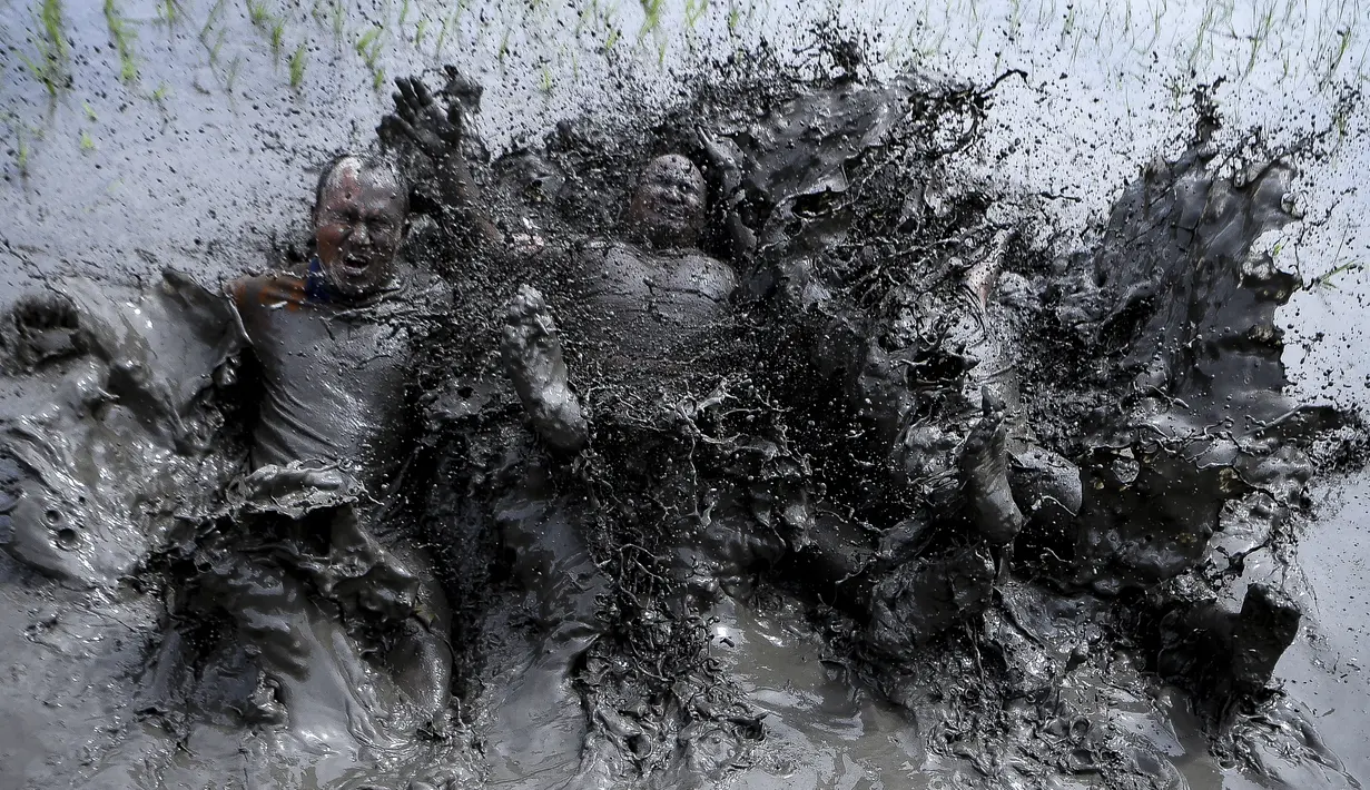 Petani bermain lumpur saat memeriahkan Hari Padi Nasional di desa Tokha di pinggiran Kathmandu, Nepal, Selasa (29/6/2021). Para petani di Nepal merayakan Hari Padi Nasional sebagai musim tanam padi tahunan dimulai. (AFP/Prakash Mathema)