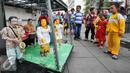 Sebuah gerobak kayu dengan genset serta sound system seadanya tampak dikerubungi anak-anak yang terlihat penasaran melihat 8 boneka kayu menari mengikuti irama musik di pelataran Museum Fatahillah, Jakarta, Kamis (17/12/2015). (Liputan6.com/Yoppy Renato)