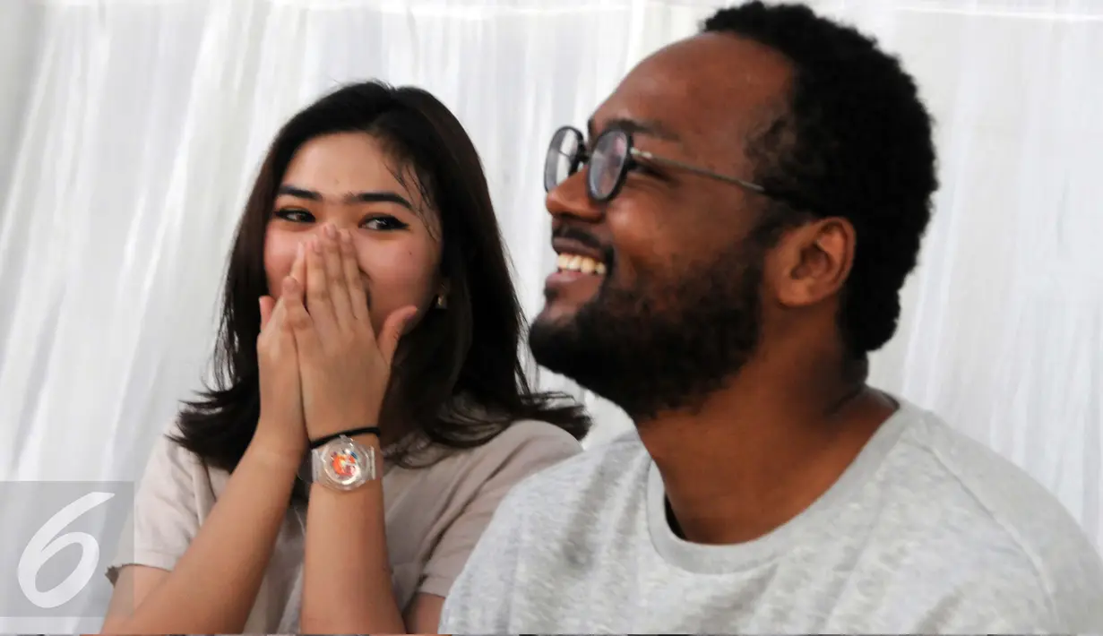 Isyana Sarasvati dan personel Dekat, Mohammed Kamga seusai latihan bersama Erwin Gutawa Orchestra di kawasan Cilandak, Jakarta, Minggu (21/8). Isyana dan Kamga akan duet pada malam puncak HUT SCTV ke-26. (Liputan6.com/Helmi Afandi)