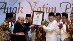 Ketua Umum Partai Golkar, Setya Novanto (kedua kanan) mengangkat penghargaan dari MURI jelang buka puasa AMPG bersama ribuan anak yatim piatu di Jakarta, Sabtu (18/6). Acara diikuti sekitar 26 ribu anak yatim piatu. (Liputan6.com/Helmi Fithriansyah)
