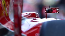 Refleksi pebalap Ferrari, Kimi Raikkonen, dari spion mobilnya saat latihan bebas pertama dalam F1 GP Abu Dhabi di Sirkuit Yas Marina, Abu Dhabi, (27/11/2015). (AFP/Andrej Isakovic)