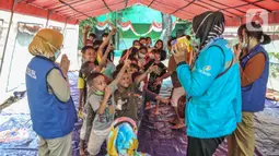 Anak-anak mendapatkan makanan usai mendengarkan dongeng di tenda pengungsian di SDN 09 Kebon Kosong, Kemayoran, Jakarta, Selasa (31/8/2021). Kegiatan bertujuan menghilangkan trauma atau rasa takut serta kebosanan anak-anak korban kebakaran saat berada di pengungsian. (merdeka.com/Iqbal S. Nugroho)