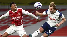 Penyerang Tottenham Hotspur, Harry Kane (kanan) menyundul bola di depan bek Arsenal, Gabriel dalam derby London Utara Liga Inggris di Emirates Stadium, Minggu (14/3/2021). Sempat tertinggal lebih dulu, Arsenal menang 2-1 di kandang sendiri melawan Tottenham Hotspur. (Dan Mullan/Pool via AP)
