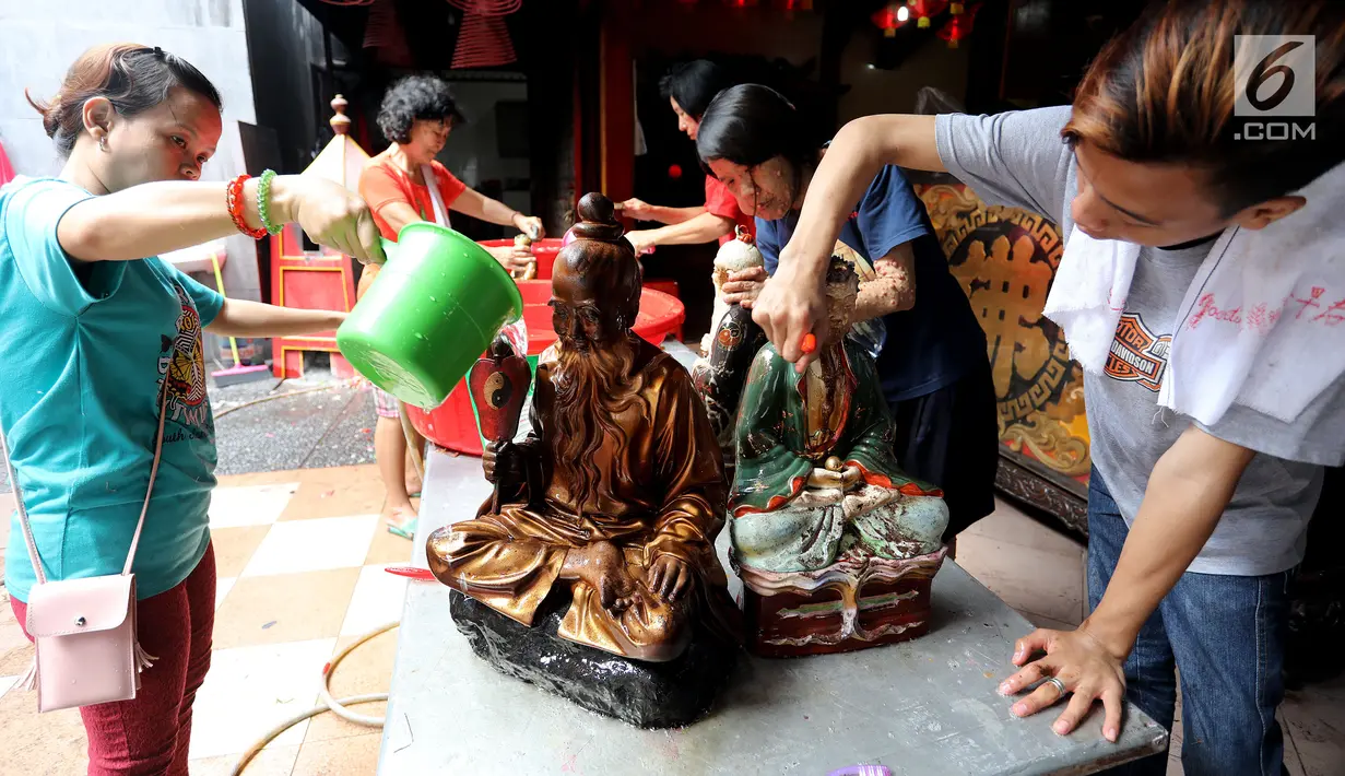 Sejumlah pengurus dan warga mencuci patung dewa yang ada di Kelenteng Toasebio, Jalan Kemenangan III, Glodok, Jakarta Barat, Jumat (9/2). Naiknya ruh para dewa ke nirwana dimanfaatkan pengurus untuk membersihkan kelenteng. (LIputan6.com/Johan Tallo)