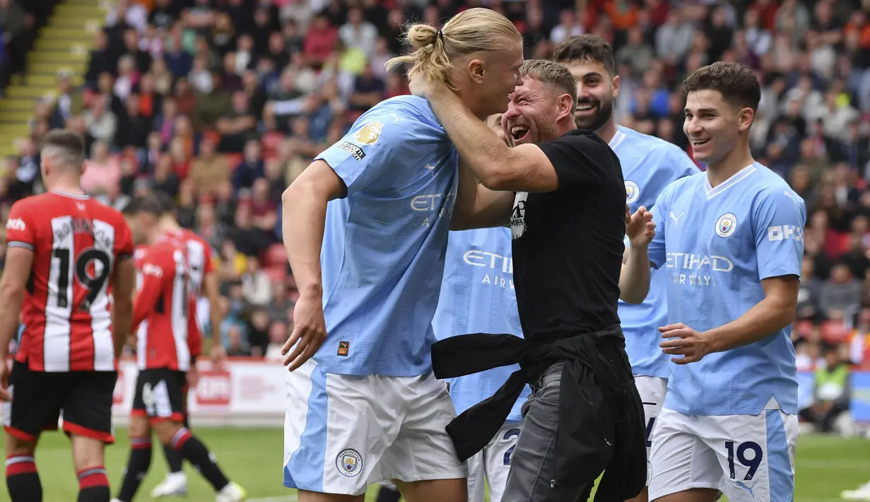 Setelah mencetak gol, Haaland terlihat berjalan pelan di pinggir lapangan. Pada saat yang bersamaan ada fans City yang melompat dan berusaha memeluk Haaland. (AP Photo/Rui Vieira)