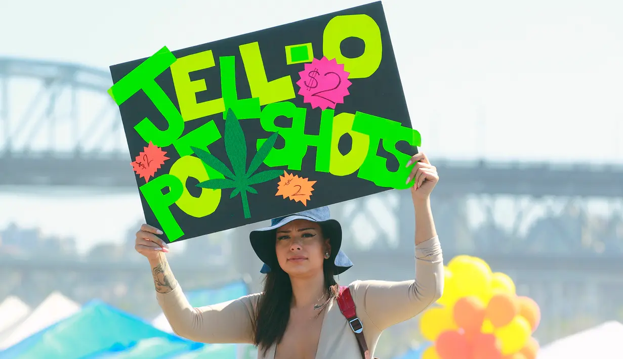 Wanita menjual tabung penghisap ganja saat merayakan acara legalisasi ganja 4/20 di Sunset Beach, Vancouver, Kanada (20/4). Legalisasi ini telah menjadi janji kampanye utama perdana menteri yang baru terpilih, Justin Trudeau. (AFP/Jeff Vinnick)