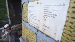Warga menunjukkan papan informasi tentang terowongan Sasaksaat, Bandung Barat, Jawa Barat, Selasa (5/7). Terowongan jalur kereta api tersebut dibangun oleh SS (Staatsspoorwegen) antara tahun 1902-1903. (Liputan6.com/Immanuel Antonius)