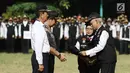 Ketua Pokdarkamtibmas Polda Metro Jaya Heru Riyadi memberikan rompi ke Wakapolda Metro Jaya, Brigjen Pol Purwadi saat apel besar di lapangan Sabhara Mapolda Metro Jaya, Jakarta, Sabtu (12/5). (Liputan6.com/Herman Zakharia)