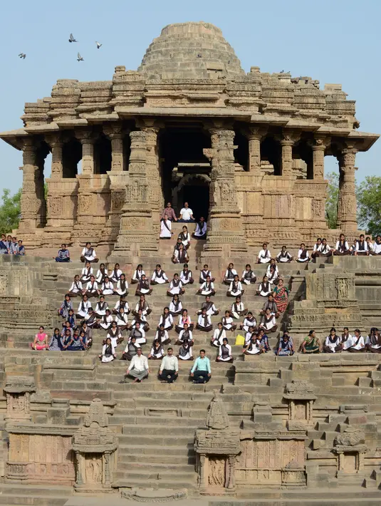Para siswa mengikuti sesi yoga untuk menandai Hari Yoga Internasional di Kuil Matahari di Modhera, India (21/6). Seluruh dunia pada 21 Juni memperingati Hari Yoga Internasional tahunan yang keempat. dimulai. (AFP Photo/Sam Panthaky)