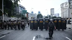 Anggota brimob memukul mundur massa aksi di kawasan Tanah Abang, Jakarta, Selasa (13/10/2020). Hingga menjelang magribh massa masih melakukan perlawan di kawasaan tersebut. (Liputan6.com/Faizal Fanani)