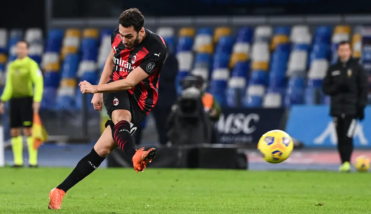 Gelandang AC Milan Hakan Calhanoglu menendang bola saat bertanding melawan Napoli pada pertandingan Liga Serie A Italia di stadion San Paolo di Naples pada 22 November 2020. (AFP/Andreas Solaro)