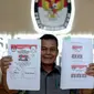 Kepala Subag Penyusunan Norma Desain dan Standar Kebutuhan Pemilu Biro Perencanaan Data KPU Sahono  menunjukan dua contoh surat suara untuk Pilkada Serentak 9 Desember 2015 di Gedung KPU, Jakarta, Rabu (11/11). (Liputan6.com/Faizal Fanani)