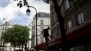 Seorang pekerja membersihkan tenda sebuah restoran, di Paris, Senin (17/5/2021). Teras luar kafe dan restoran Prancis akan diizinkan untuk dibuka kembali pada 19 Mei bersama dengan museum, bioskop, teater, dan ruang konser dalam kondisi tertentu. (AP Photo/Thibault Camus)