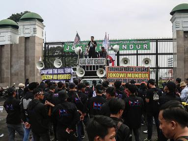 Demonstran berorasi saat berunjuk rasa di depan Gedung MPR/DPR/DPD, Jalan Gatot Subroto, Jakarta, Jumat (20/5/2022). Demonstran menuntut berbagai isu, di antaranya Omnibus Law dan penurunan harga sembako serta bahan bakar minyak (BBM). (Liputan6.com/Johan Tallo)