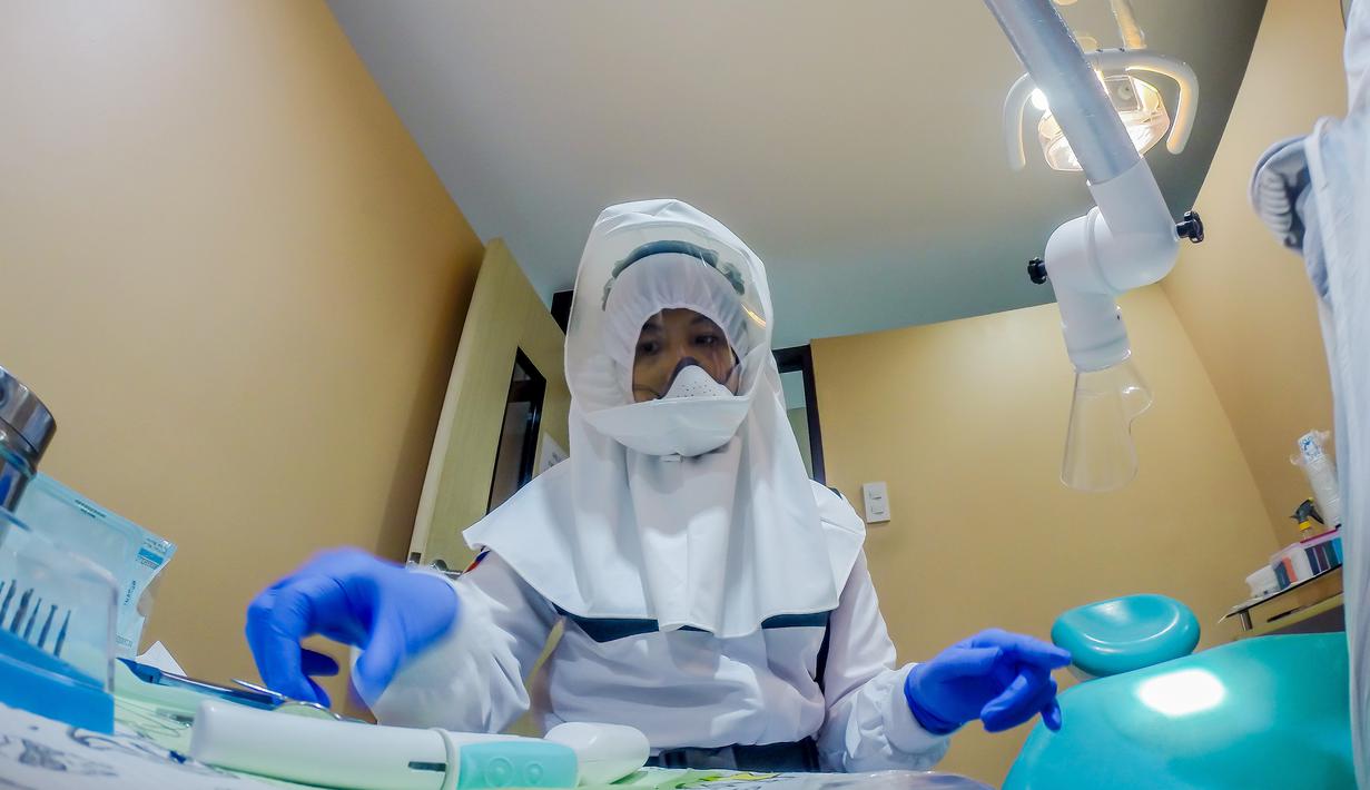 Dr. Maureen P. Ines-Manzano, seorang dokter gigi, mempersiapkan peralatannya di dalam kliniknya di Manila, Filipina, 19 Oktober 2020. Pasien Dr. Manzano menjulukinya "dokter gigi astronaut" karena mengenakan setelan PAPR untuk melindungi pasien dan dirinya dari COVID-19. (Xinhua/Rouelle Umali)