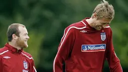 Wayne Rooney and Peter Crouch share a joke as they walk to the training ground for training at London Colney, North London, on October 7, 2008. AFP PHOTO/Glyn Kirk