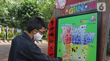 Pengunjung melihat denah Taman Margasatwa Ragunan (TMR), Jakarta Selatan, Sabtu (26/12/2020). Meskipun pandemi covid-19 masih terjadi, sejumlah warga tetap mengunjungi Ragunan di libur panjang Natal 2020 ini. (Liputan6.com/Herman Zakharia)