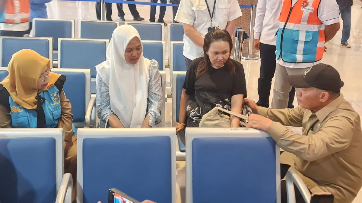 Umi istri salah satu penumpang KM Virgo menunjukkan foto sang suami. (merdeka.com/Erwin yohanes).