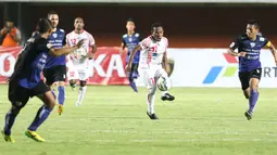Pemain Persipura Jayapura, Ferinando Pahabol mengecoh para pemain Arema Cronus pada laga grup E Piala Jenderal Sudirman di Stadion Maguwoharjo, Sleman, Minggu (13/12/2015) (Bola.com/Nicklas Hanoatubun) 