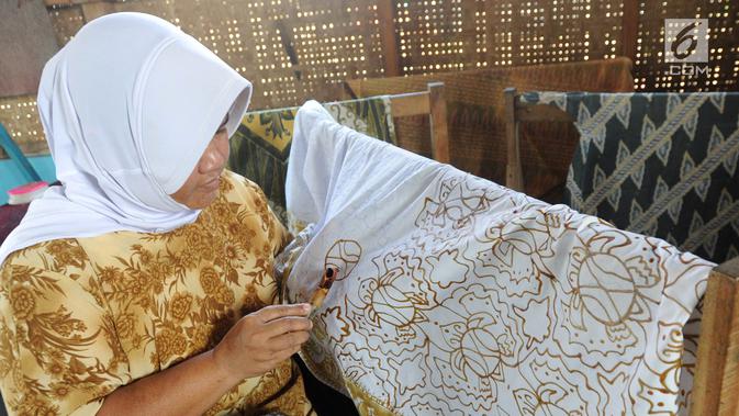Seorang ibu membuat batik tulis di Kampung Batik Puswasedar kawasan Geopark Ciletuh, Sukabumi, Jawa Barat, Sabtu (22/9). Kaum perempuan mulai menekuni pembuatan batik mulai tahun 2015. (Merdeka.com/Arie Basuki)