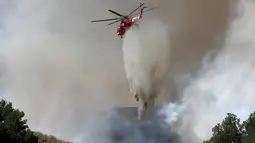 Helikopter membantu memadamkan api yang melanda Hutan Nasional Angeles dekat Los Angeles, California, AS (24/7). Setidaknya terdapat 300 orang yang telah dievakuasi oleh pihak berwenang ke tempat yang lebih aman, di luar kota. (REUTERS / Jonathan Alcorn)