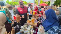 Menpora Dito Ariotedjo menyempatkan diri melihat gerai UMKM yang berjejer saat pelaksanaan Pekan Olahraga Tradisional Nasional (Potradnas) 2023 di Open Space Gallery Linggarjati, Kuningan, Jawa Barat. (Bola.com/Dok. Kemenpora)