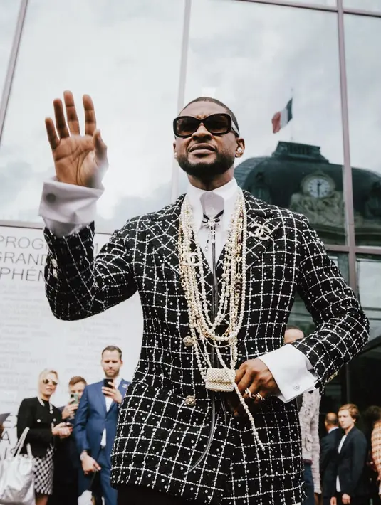 Gaya Usher juga terbilang nyentrik. Ia kenakan blazer tweed dengan tambahan aksesori mutiara bertumpuk khas Chanel. [Foto: Chanel.Dok]