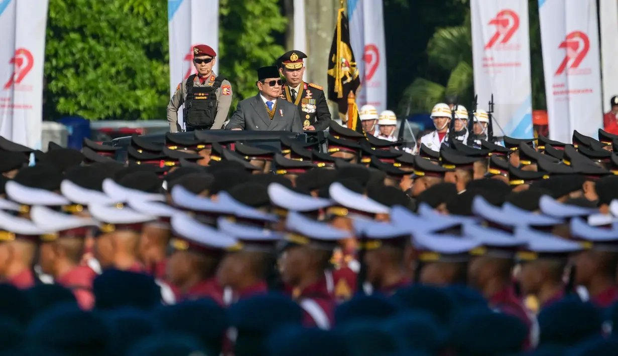 Presiden Republik Indonesia, Prabowo Subianto (tengah) didampingi Kepala Kepolisian Republik Indonesia (Kapolri) Jenderal Polisi Listyo Sigit Prabowo memeriksa pasukan saat seremoni puncak Hari Bhayangkara ke-79 nan diselenggarakan di Lapangan Monumen Nasional (Monas), Jakarta pada Selasa 1 Juli 2025. (BAY ISMOYO/AFP)