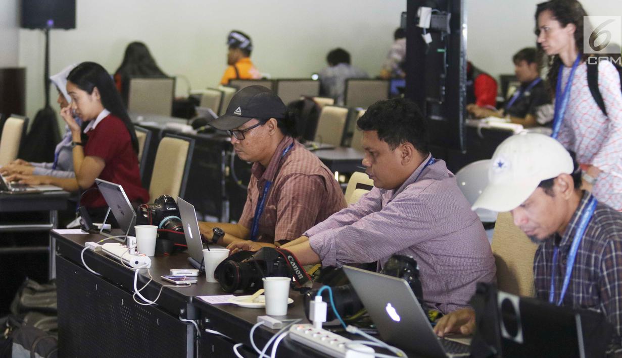 Jurnalis berbagai negara mengetik berita pertemuan tahunan IMF-Bank Dunia di Nusa Dua, Bali, Senin (8/10). Menkominfo Rudiantara memastikan fasilitas internet kencang untuk tamu dan media dalam pertemuan tahunan ini. Liputan6.com/Angga Yuniar)